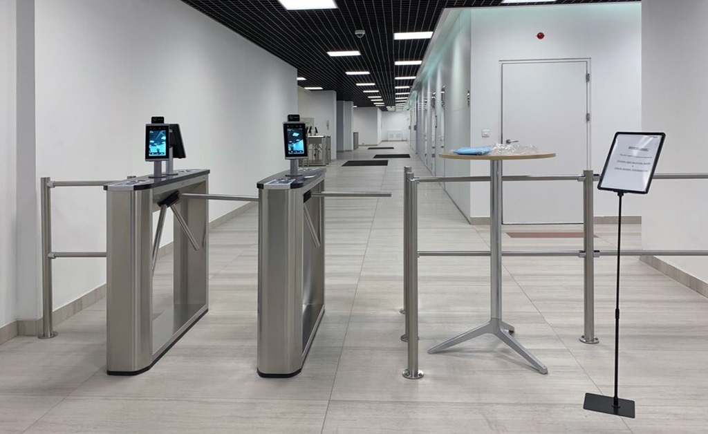 Enoxson's tripod turnstile integrated with a face reader, illustrating a modern and secure access control system for commercial buildings